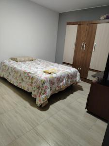 1 dormitorio con 1 cama con edredón de flores en Departamento moderno en el centro de la ciudad, en Ilo