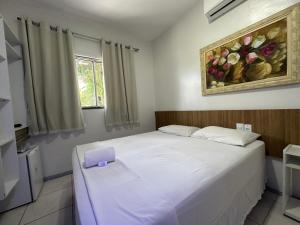 a bedroom with a bed with a purple box on it at Hotel Aeroporto Montese Star in Fortaleza
