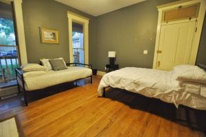 a bedroom with a bed and a couch and a window at The Troubadour- Location Location in Columbus