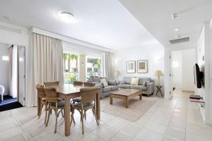 a living room with a table and a couch at Laguna on Hastings, Apartment 117, Noosa Heads in Noosa Heads