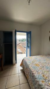 um quarto com uma cama e uma porta aberta em Hostel e Pousada Mineira em Ouro Preto