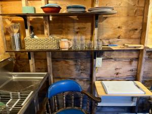 eine Küche mit einem blauen Stuhl, einem Tisch und Regalen in der Unterkunft EcoCottage Private Hot Tub in Union