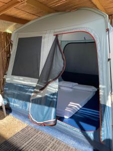 une tente ouverte avec un lit dans l'établissement Russell Place Tent, à Port Barton
