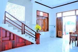 a living room with a staircase and a table and chairs at Nybipu Homestay in Phan Rang +4 photos