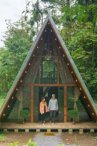 two people standing in the front of a triangular house at Pozas y Cataratas La Presa in Ángeles