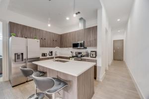 a kitchen with a white counter and chairs in it at Snappy loft style 2BR I Gym I Parking I Workspace in Dallas