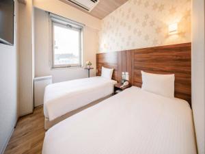 En eller flere senge i et værelse på Tokai City Hotel