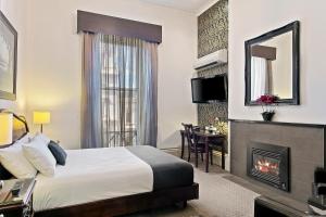 a hotel room with a bed and a fireplace at Quality Inn Heritage on Lydiard in Ballarat
