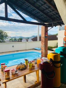 a table with food on it next to a swimming pool at Mandallah Hostel in Joinville