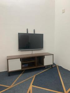 ポートディクソンにあるHomestay Rayyan PDのエンターテイメントセンターの上に座って薄型テレビを見ることができます。