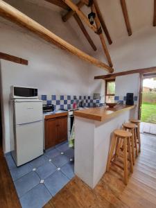 庫斯科的住宿－Magico bungalow en tambillo，厨房配有白色冰箱和带凳子的台面