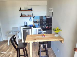 a kitchen with a wooden table and two stools at Sea Breeze inn 102 in Providencia