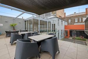 eine Terrasse mit Tischen und Stühlen auf dem Balkon in der Unterkunft Quality Inn Heritage on Lydiard in Ballarat