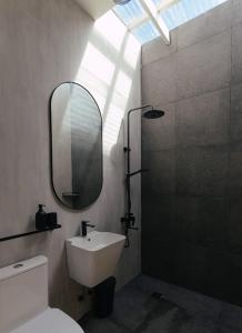 La salle de bains est pourvue d'un lavabo, d'un miroir et d'une douche. dans l'établissement Katig Beachfront Boutique Hotel, à General Luna