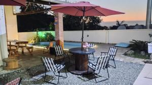 a patio with a table and chairs and an umbrella at Mandallah Hostel in Joinville