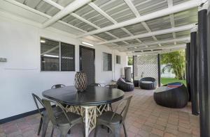 a patio with a table and chairs and a couch at Castle View Cottage in Townsville