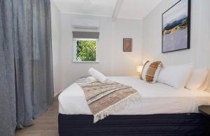 a bedroom with a bed with a blanket on it at Castle View Cottage in Townsville