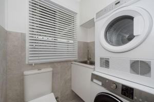 uma casa de banho com uma máquina de lavar roupa e um WC em Castle View Cottage em Townsville