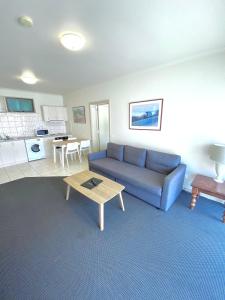 sala de estar con sofá azul y mesa en Ballarat Colonial Motor Inn, en Ballarat