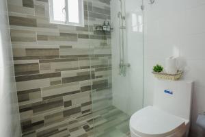 a bathroom with a toilet and a glass shower at Luxury Penthouse in San Francisco de Macorís