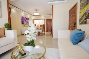 a living room with a white couch and a table at Luxury Penthouse in San Francisco de Macorís