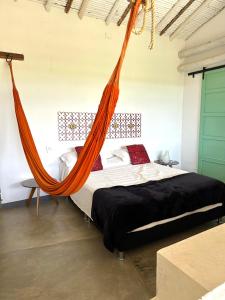 a bed with an orange hammock in a room at LOFT SAJA. Diseño en tapia pisada contemporáneo in Barichara
