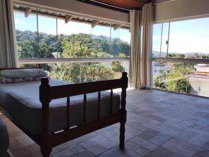 ein Schlafzimmer mit einem Bett vor einem großen Fenster in der Unterkunft Mandallah Hostel in Joinville