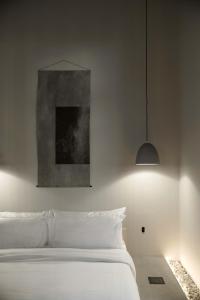 a bedroom with a white bed and a painting at kodō hotel in Los Angeles
