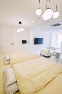 高知的住宿－「まちのアトリエ」STAY UWU 004，卧室拥有白色的墙壁和一张黄色床单