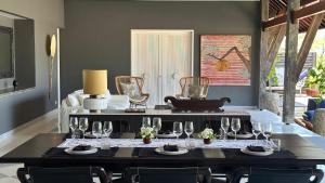 een eetkamer met een tafel met wijnglazen erop bij Meno House - Adults Only in Gili Meno