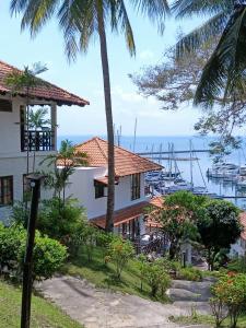 una casa con una palma accanto a un porto turistico di Sea View Villa @ Nongsa Resort a Telukmataikan
