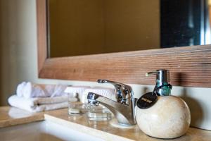 a bathroom sink with a soap dispenser on it at Meruhdani Boutique Hotel Ubud in Ubud