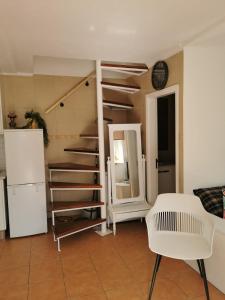 uma sala de estar com uma escada e uma cadeira branca em Castro Marim Al Sarita Villa em Castro Marim