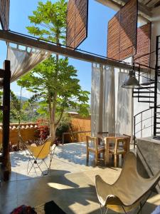a patio with chairs and a table and a tree at LOFT SAJA. Diseño en tapia pisada contemporáneo in Barichara