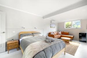 ein Schlafzimmer mit einem Bett und einem Sofa in der Unterkunft Red Rocks Golf & Accommodation - Phillip Island in Cowes