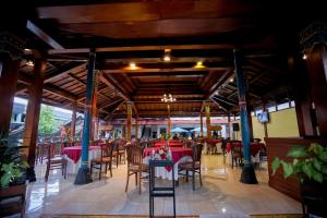 een leeg restaurant met tafels en stoelen en een tafelblad bij Cakra Kusuma Hotel in Yogyakarta
