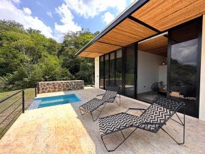 a patio with two chairs and a swimming pool at Wayma House in Villeta