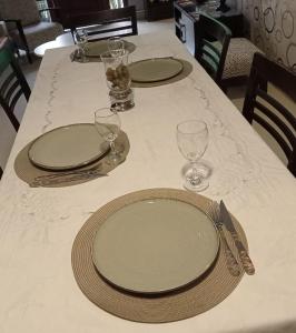 a table with plates and wine glasses on it at Infinit Home Duplex entero in Termas de Río Hondo