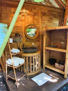 - une salle de bains pourvue d'un lavabo dans une cabine en bois dans l'établissement Wahem Eco Bamboo, à Ubud