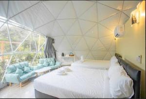 a room with two beds and a large window at Evie Mae Camp in Ban Cha-om