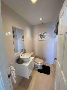 La salle de bains blanche est pourvue d'un lavabo et de toilettes. dans l'établissement 702 w/ a view at Princess Heights, à Dawn Beach