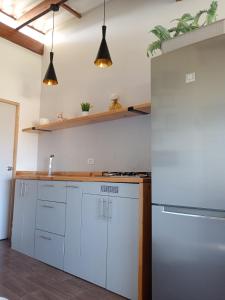 uma cozinha com armários brancos e um frigorífico em Casa Naranja em Máncora