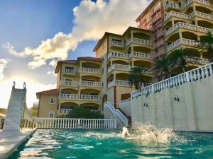 a swimming pool in front of a large building at 702 w/ a view at Princess Heights in Dawn Beach
