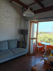 a living room with a couch and a table at Casa Naranja in Máncora