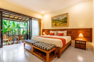 ein Schlafzimmer mit einem großen Bett und einem Balkon in der Unterkunft Meruhdani Boutique Hotel Ubud in Ubud