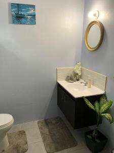 a bathroom with a sink and a toilet and a mirror at The Blue Moroccan Door - A modern 3 bedroom,2 bathroom home 