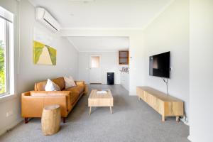 ein Wohnzimmer mit einem Sofa und einem Tisch in der Unterkunft Red Rocks Golf & Accommodation - Phillip Island in Cowes