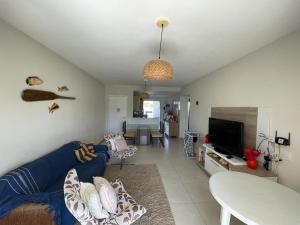 a living room with a blue couch and a tv at Casa Térrea - Villa das Águas - Praia do Saco in Estância