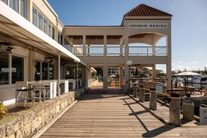 een gebouw met een houten promenade naast een jachthaven bij Boardwalk Bliss - Explore the Lively Mindarie Marina in Mindarie