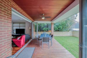 a screened in patio with a table and chairs at Rivervale Retreat - Spacious Family Living in Perth